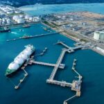 Energy Estimating - LNG (Liquified Natural Gas) tanker anchored in Gas terminal gas tanks for storage. Oil Crude Gas